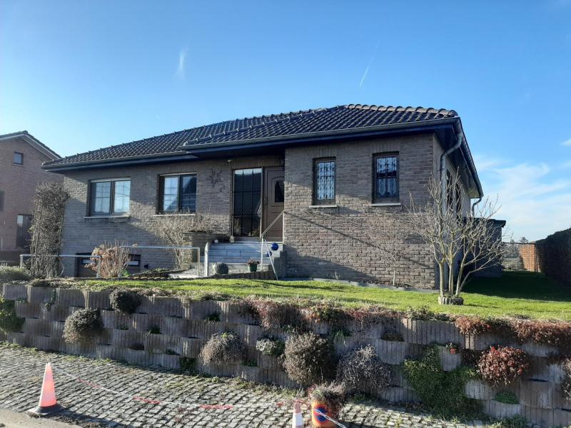 Cette maison se situe dans un cul de sac, qui garantit une tranquilité totale. Maison en parfait état et très soignée. Ce bungalow a été construit en 1990 et dispose de trois chambres à coucher. Entouré d'un joli jardin avec orientation sud-ouest, la parcelle s'étend sur 621 m².
La surface habitable est de +/- 115 m² et se compose comme suit: hall d'entrée avec un WC, grand living qui abrite une cheminée ouverte non-utilisée mais avec la possiblité de l'activer, accès direct à la terrasse et jardin avec vue dégagée, cuisine complètement équipée accésible du salon-living. De plus il y a trois chambres à coucher, une salle de bain avec douche, double lavabo et WC. Toute la maison est sous cave avec un très grand garage, qui offre beaucoup de  place,une buanderie,des caves de stockage, un SAS avec lavabo et finalement le chauffage au gaz.    
Superbe situation dans un cul de sac, jardin tout autour, carrelages, volets (partiellement électriques), maison dans un excellent état et entourée d'un paysage pittoresque.
Toutes les commodités (magasins, écoles, station de bus, chemin de fer, ...) se trouvent à proximité.
